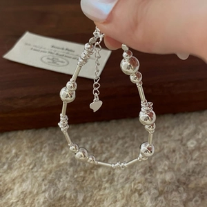 Vue détaillée du bracelet en argent S925 avec breloque cœur et perles polies de style minimaliste
