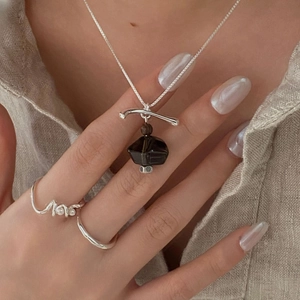 Close-up of a S925 silver necklace with a smoky quartz pendant and matching irregular ring