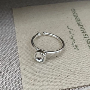 Close-up of minimalist S925 silver square ring with dark gemstone on linen background