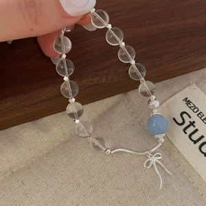 Detailed close-up of S925 silver beaded bracelet with blue crystal and bow pendant