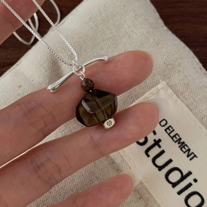 Detail of S925 silver necklace with smoky quartz pendant and floral embossed bead detail