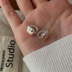 Macro shot of silver square geometric huggie earrings with a high-polished mirror finish