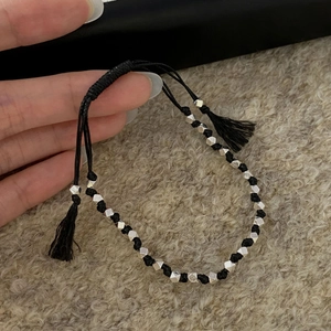 Bracelet tressé à la main en corde noire avec perles argentées et détails pompons