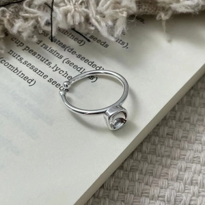Macro view of geometric square-cut clear gemstone on a minimalist S925 silver ring