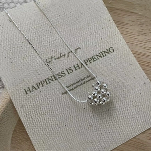 Gros plan détaillé d'un collier cœur en perles d'argent S925 sur une élégante carte cadeau