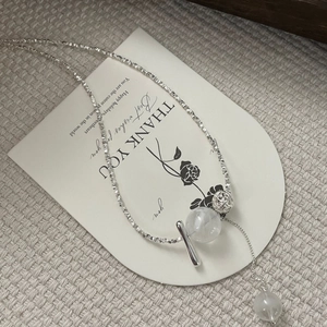 Détail du collier en argent sterling S925 avec une boule en métal ajourée et perle de cristal