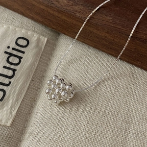 Gros plan d'un pendentif cœur en perles d'argent S925 avec fine chaîne collier