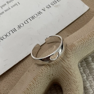 Bague ouverte en argent fin S925 poli avec motif cœur évidé sur support en bois