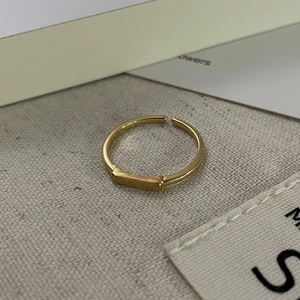 Macro shot of 18K gold S925 sterling silver stamp on minimalist geometric square ring