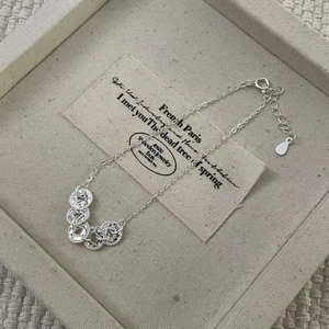 Detailed macro view of S925 silver coin charm bracelet with adjustable extender chain
