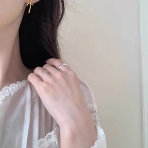 Détail de la bague coeur évidée en argent S925 et boucle d'oreille nœud doré sur modèle