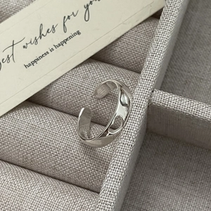 Gros plan d'une bague cœur ajourée en argent S925 dans un coffret en velours
