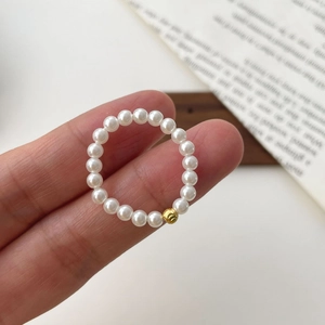 Elegant S925 silver elastic ring with round white pearls and a gold bead accent