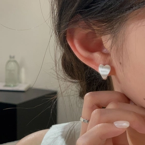 Detail showing the brushed texture of a heart-shaped S925 silver stud earring and matching ring