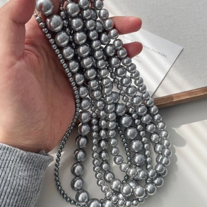 Handheld view of multi-strand silver grey faux pearl necklaces with high luster metallic finish