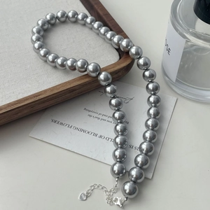 Detail of silver-grey pearl necklace with S925 sterling silver lobster clasp and heart charm