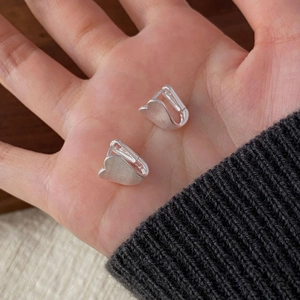 Detailed close-up of heart-shaped S925 silver earrings with a brushed metal matte texture