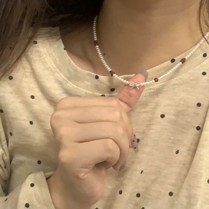 Détail du pendentif nœud en argent S925 et du collier de perles blanches pour femme