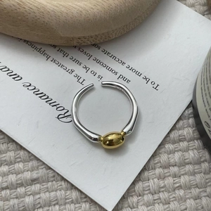 Detailed macro view of S925 silver ring featuring a two-tone gold and silver irregular design