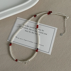 Détails macro des nœuds en argent S925 et des perles rondes sur un collier perlé
