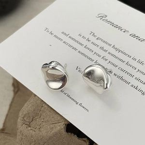 Macro shot of irregular liquid metal silver stud earrings with high mirror finish