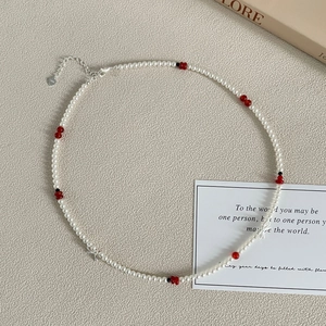 Détail du fermoir en argent S925 et des pendentifs nœuds sur un collier de perles