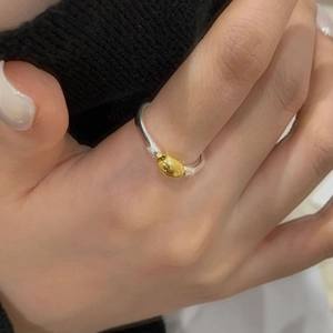 Close-up of a minimalist S925 silver ring featuring a two-tone gold oval bead design