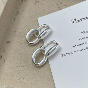 Macro detail of S925 sterling silver hollow oval earrings on minimalist stone texture
