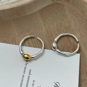 Detailed macro view of S925 sterling silver irregular open rings with gold bead accent