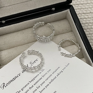 Detailed macro view of S925 sterling silver stacked rings with woven and grid texture patterns