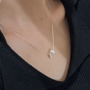 Détail d'un collier en argent S925 avec perle brossée et pendentif barre verticale
