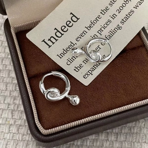 Detail of S925 sterling silver twisted hoop earrings with teardrop pendants in a brown box
