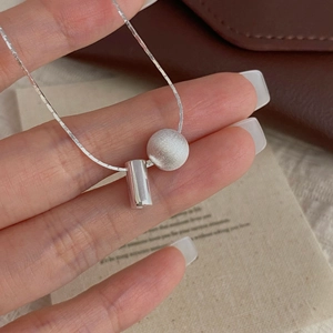 Gros plan du collier en argent sterling S925 avec boule brossée mate et pendentif cylindre