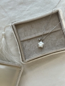 Gros plan du collier étoile en argent S925 avec perle naturelle et pendentif