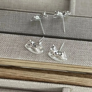 Detailed macro view of S925 sterling silver rocking horse stud earrings with diamond accents