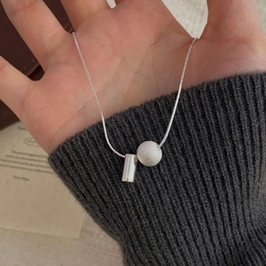 Détail du collier en argent S925 avec pendentif cylindre poli et perle au fini brossé