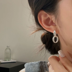 Close-up of elegant S925 sterling silver hollow oval drop earrings worn by a model
