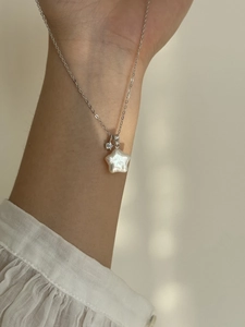 Détail du collier en argent S925 avec perle étoile et diamant sur le bras du mannequin