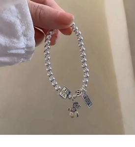 Close-up of S925 silver beaded bracelet with fortune horse and coin charms for women