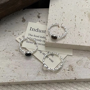 Macro shot of S925 sterling silver chain ring with white and black stones on stone background