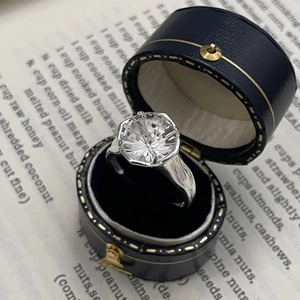 Close-up of S925 silver zircon ring with firework cut in a blue velvet jewelry box