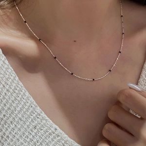Minimalist S925 sterling silver clavicle chain featuring small black enamel beads on a neck