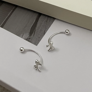 Macro detail of S925 sterling silver bow earrings with elegant C-shaped curved design
