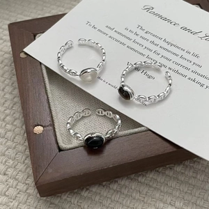 Detailed view of S925 sterling silver chain rings with white and black gemstones