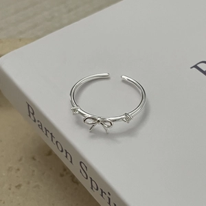 Détail de la bague nœud en argent sterling 925 avec cristaux sur un livre blanc