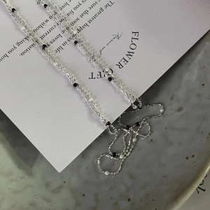 Close-up of a 925 sterling silver necklace featuring delicate black and white enamel beads