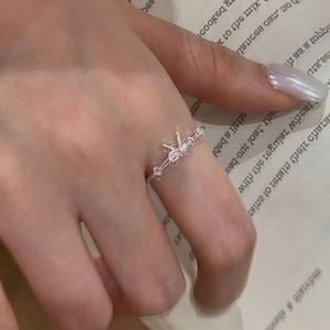 Gros plan d'une bague nœud en argent 925 avec zircons portée à l'index de la main