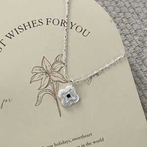 Macro detail of S925 sterling silver four-leaf clover necklace with black zircon stone