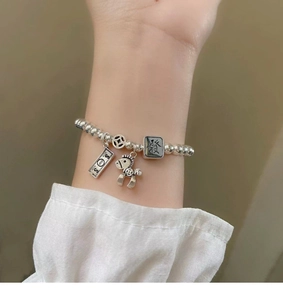 Detail view of S925 silver bracelet featuring mahjong and horse charms for good luck