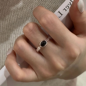 Detail view of S925 silver hollow link ring with oval black onyx gemstone on hand